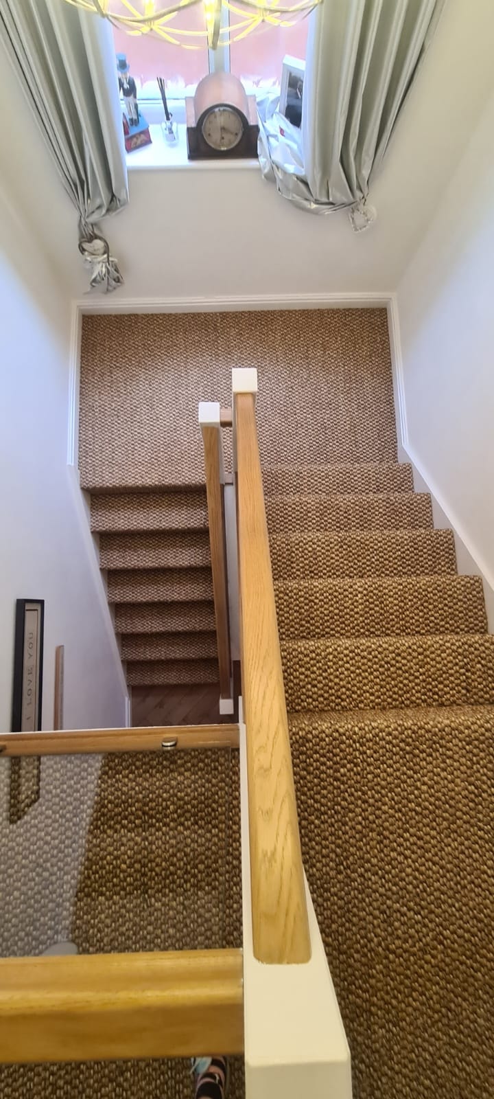 Carpeted staircase with wooden banister