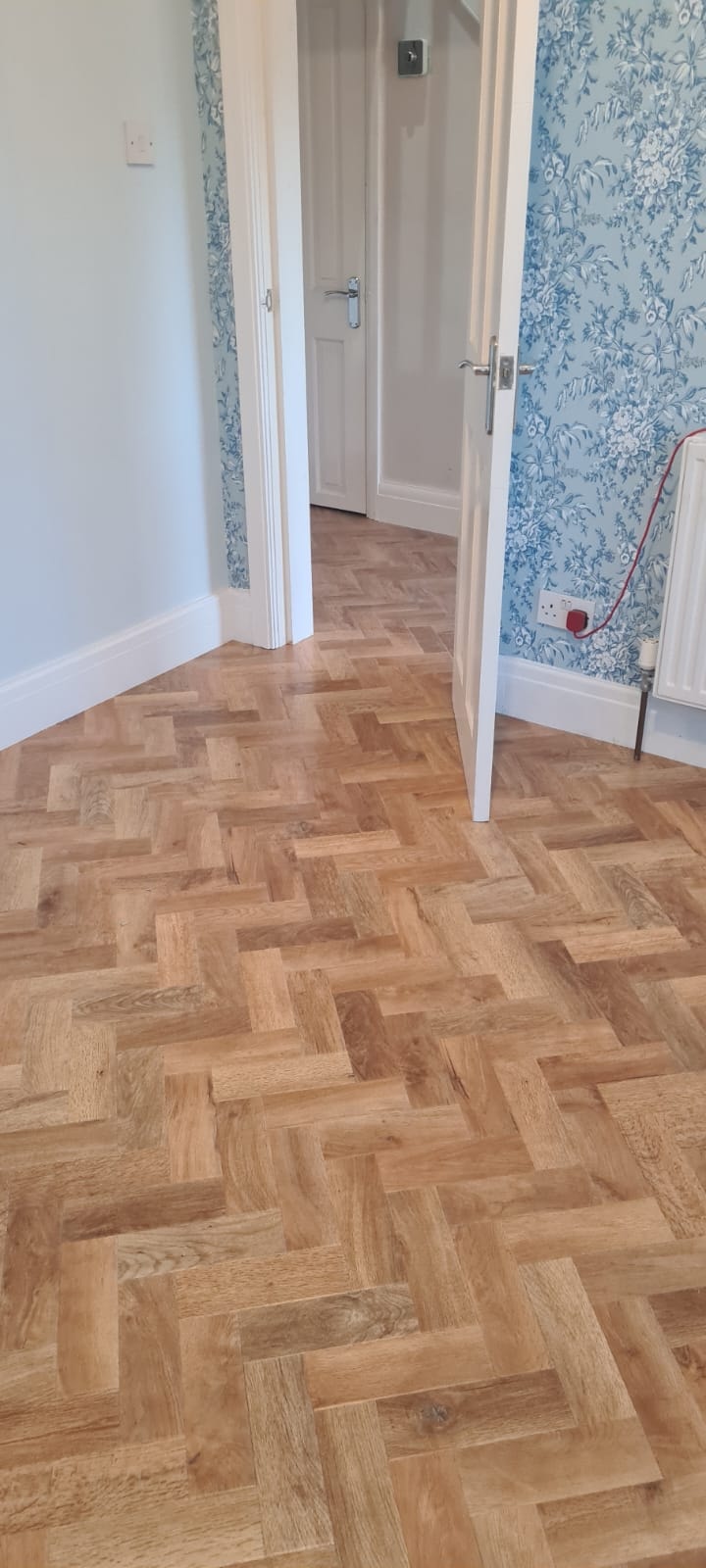 Hallway with herringbone wood flooring and doors